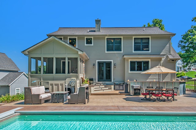 back of house with outdoor lounge area, a sunroom, and a patio area