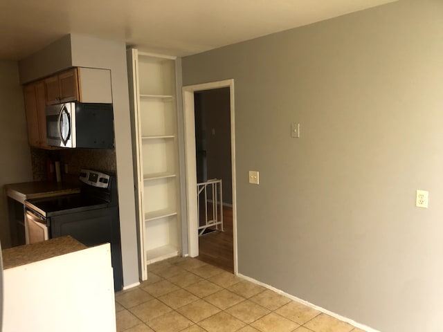 kitchen featuring range with electric stovetop and light tile patterned floors