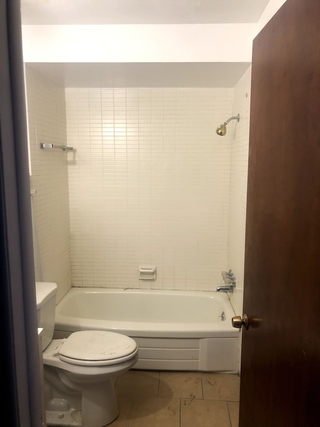 bathroom with tile patterned floors, toilet, and tiled shower / bath