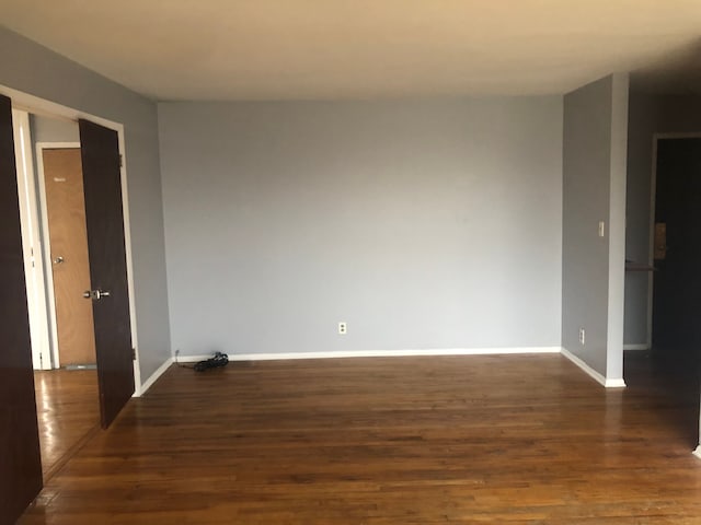 unfurnished room featuring dark wood-type flooring