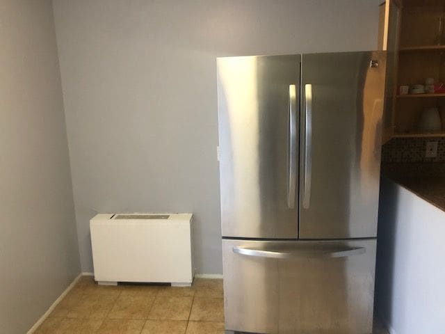 kitchen featuring stainless steel fridge and light tile patterned floors