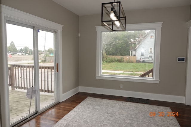 dining area with a notable chandelier and dark hardwood / wood-style floors