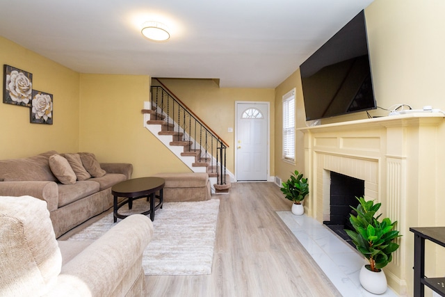 living room with a fireplace and light wood-type flooring