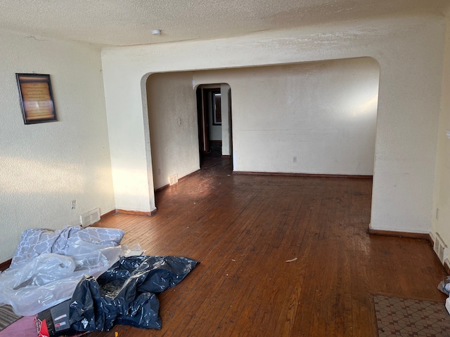 unfurnished room featuring dark hardwood / wood-style floors and a textured ceiling