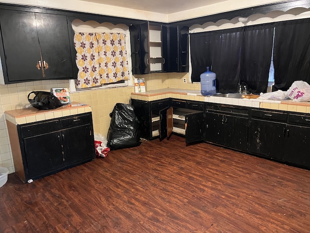 kitchen with tasteful backsplash, dark hardwood / wood-style flooring, tile counters, and sink