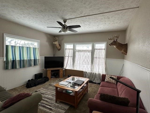 living room with ceiling fan, a healthy amount of sunlight, and a textured ceiling