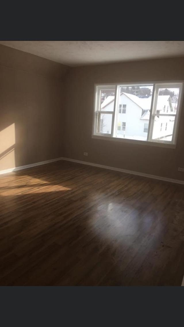 unfurnished room with dark hardwood / wood-style flooring