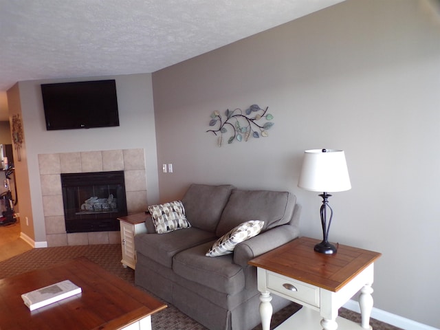 1246 Sunnyside, Cadillac, MI 49601 - living area featuring a tiled fireplace, baseboards, a textured ceiling, and carpet floors