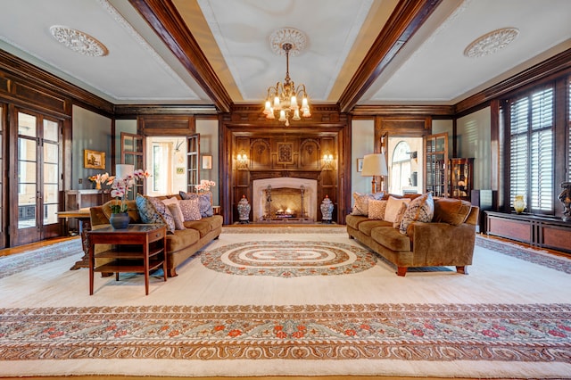 living room with an inviting chandelier, crown molding, and wood walls