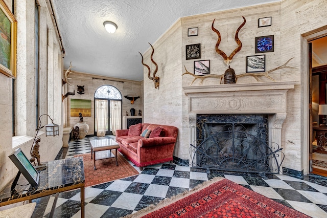 living room with a high end fireplace and a textured ceiling