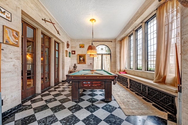 recreation room with french doors, a textured ceiling, and billiards