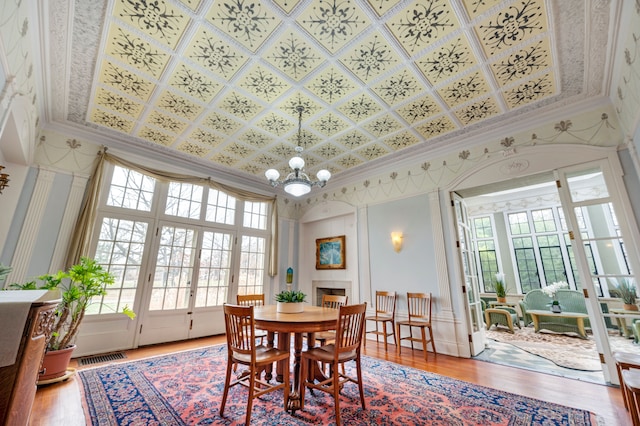 70 W Boston Blvd, Detroit, MI 48202 - dining area featuring crown molding, plenty of natural light, light wood-style floors, a chandelier, and an ornate ceiling