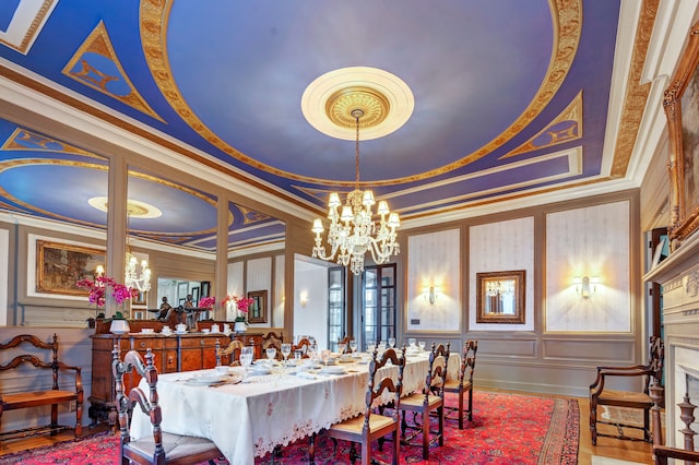 dining area with a raised ceiling, ornamental molding, and a notable chandelier