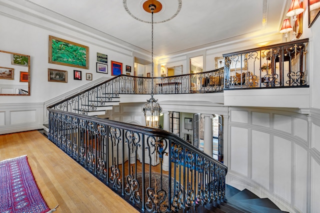 staircase with hardwood / wood-style flooring and a notable chandelier