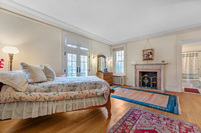 bedroom with crown molding, french doors, and hardwood / wood-style flooring