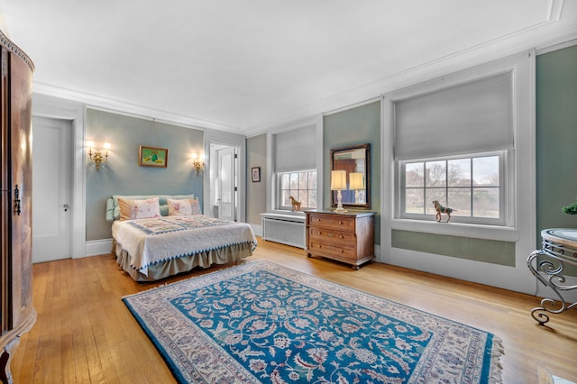 bedroom with light hardwood / wood-style floors and crown molding