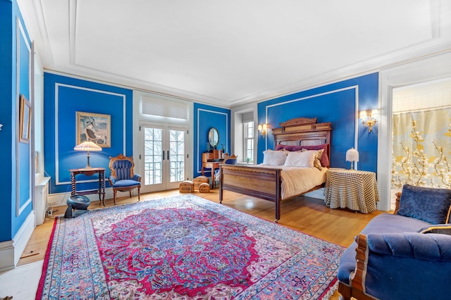 bedroom with french doors, hardwood / wood-style flooring, and ornamental molding