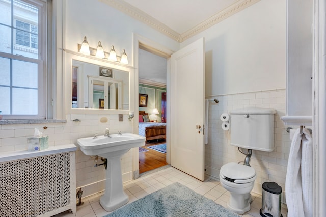 bathroom featuring radiator heating unit, tile patterned floors, tile walls, and plenty of natural light