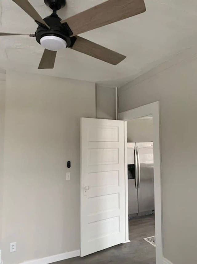 121 S Court St, Howell, MI 48843 - spare room with a ceiling fan, dark wood-style flooring, and baseboards