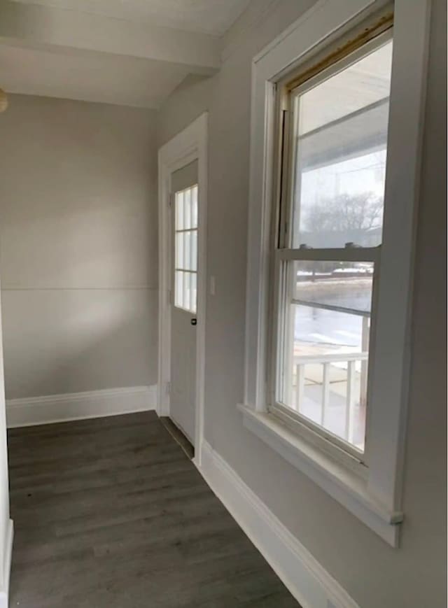 doorway featuring beamed ceiling and dark wood-type flooring