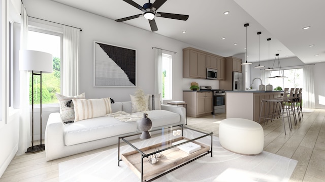 living room with light hardwood / wood-style floors, ceiling fan, and sink