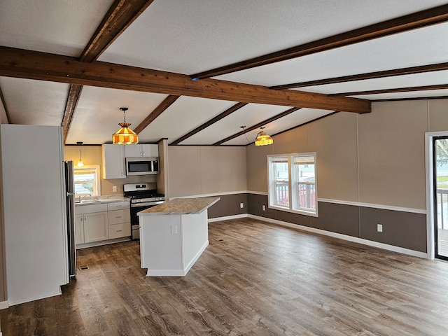 kitchen with pendant lighting, vaulted ceiling with beams, dark hardwood / wood-style floors, appliances with stainless steel finishes, and white cabinetry