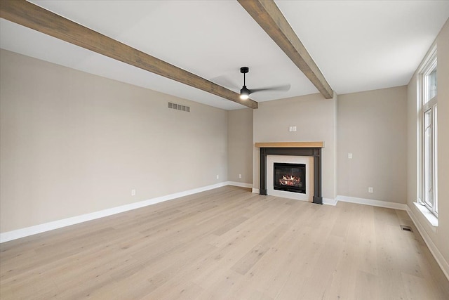 unfurnished living room with beamed ceiling, light hardwood / wood-style floors, and ceiling fan