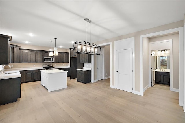 kitchen with pendant lighting, light hardwood / wood-style flooring, a kitchen island, dark brown cabinetry, and stainless steel appliances