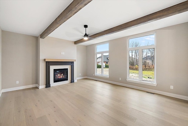 unfurnished living room featuring ceiling fan, beam ceiling, and light hardwood / wood-style flooring