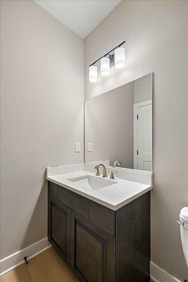 bathroom with vanity, hardwood / wood-style flooring, and toilet