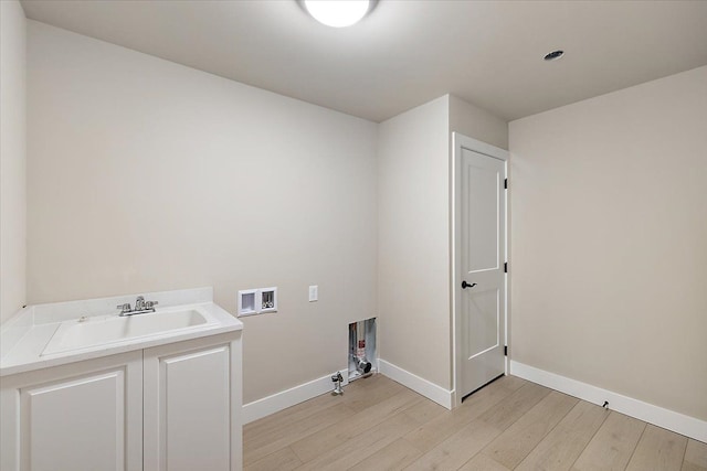 washroom featuring light hardwood / wood-style flooring, washer hookup, and sink