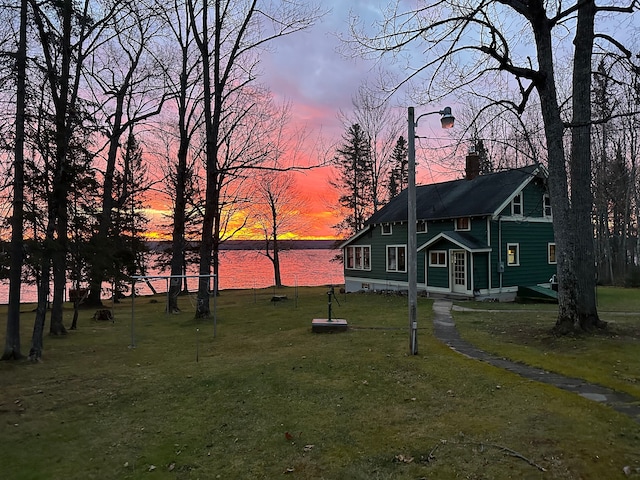 yard at dusk featuring a water view