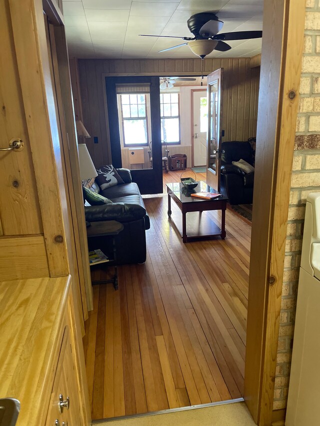 9516 State Highway M64, Marenisco, MI 49947 - living room featuring hardwood / wood-style flooring, ceiling fan, wood walls, and plenty of natural light