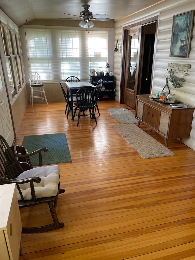 9516 State Highway M64, Marenisco, MI 49947 - dining room featuring light wood-style floors, a ceiling fan, plenty of natural light, vaulted ceiling, and rustic walls
