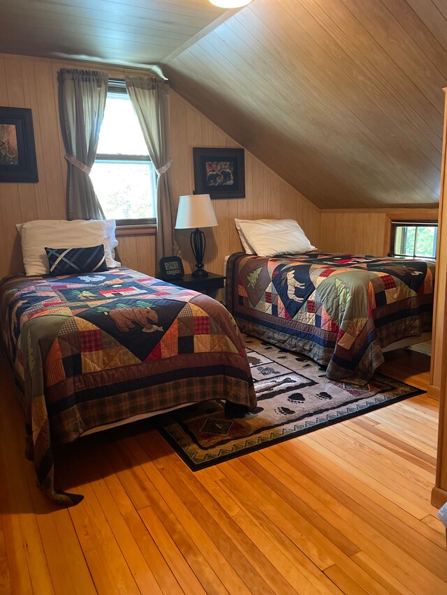 9516 State Highway M64, Marenisco, MI 49947 - bedroom featuring wood-type flooring, multiple windows, lofted ceiling, wooden walls, and wooden ceiling