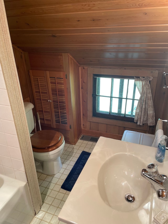 bathroom with wood walls, sink, wooden ceiling, and toilet