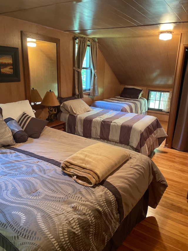 9516 State Highway M64, Marenisco, MI 49947 - bedroom featuring hardwood / wood-style floors, lofted ceiling, and wooden walls