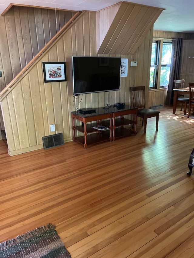 living room featuring hardwood / wood-style flooring and wooden walls