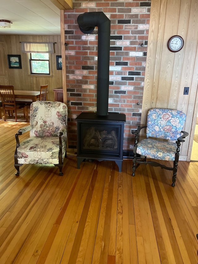 living area featuring a wood stove, wood walls, and wood-type flooring