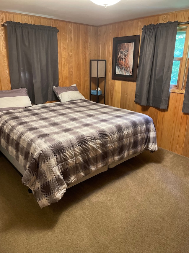 bedroom featuring wood walls and carpet