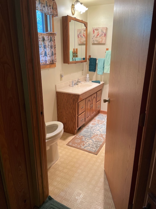 9516 State Highway M64, Marenisco, MI 49947 - half bathroom featuring vanity, toilet, and tile patterned floors