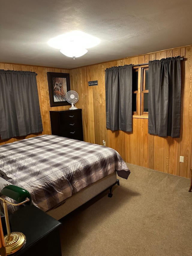 carpeted bedroom with a textured ceiling and wooden walls