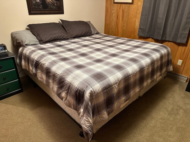 carpeted bedroom featuring wooden walls