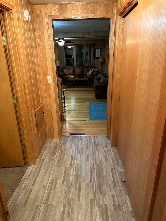 corridor with wooden walls and wood-type flooring