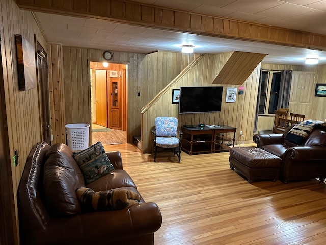 living room with light hardwood / wood-style floors and wooden walls