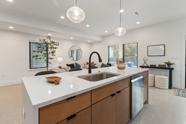 kitchen with light stone counters, stainless steel dishwasher, sink, decorative light fixtures, and an island with sink