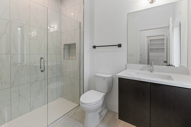 bathroom featuring tiled shower, vanity, and toilet