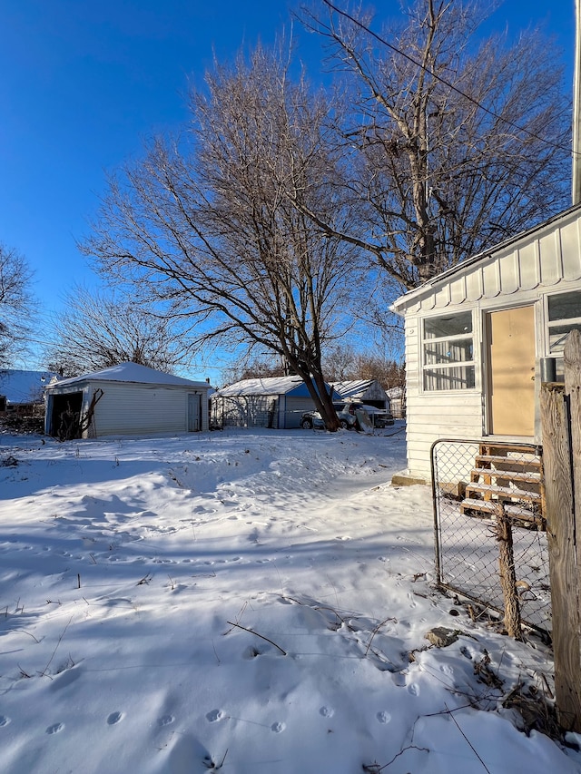 snowy yard with an outbuilding and a garage