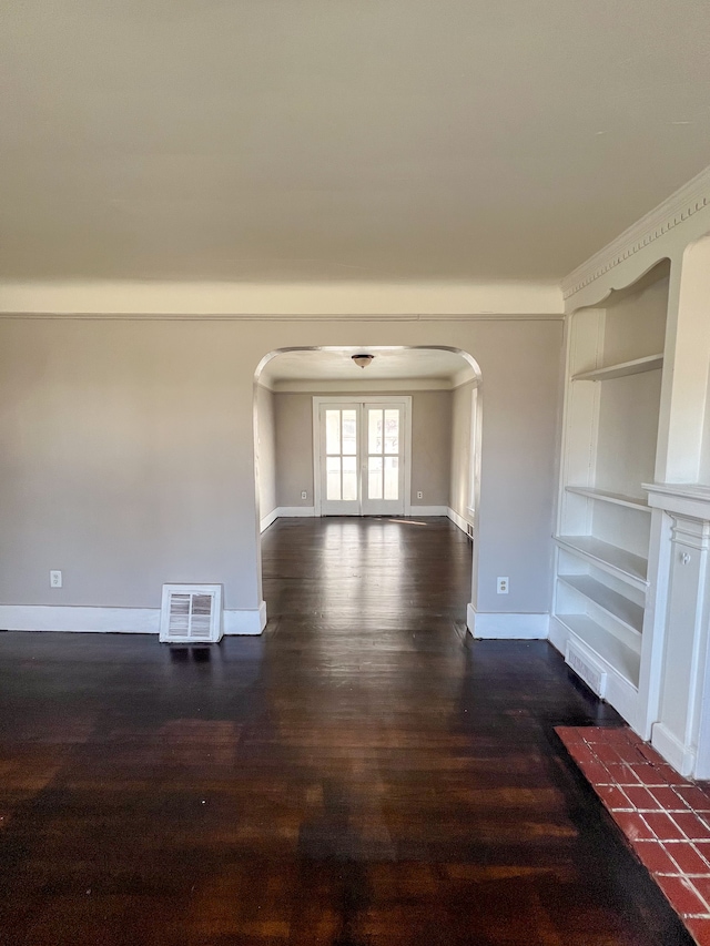 empty room featuring dark hardwood / wood-style floors and built in features