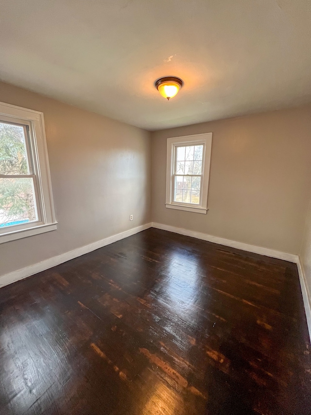 unfurnished room with dark hardwood / wood-style flooring